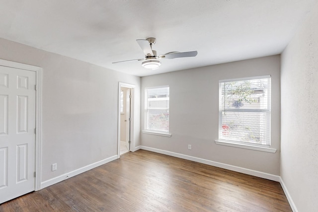 unfurnished room with ceiling fan, baseboards, and wood finished floors