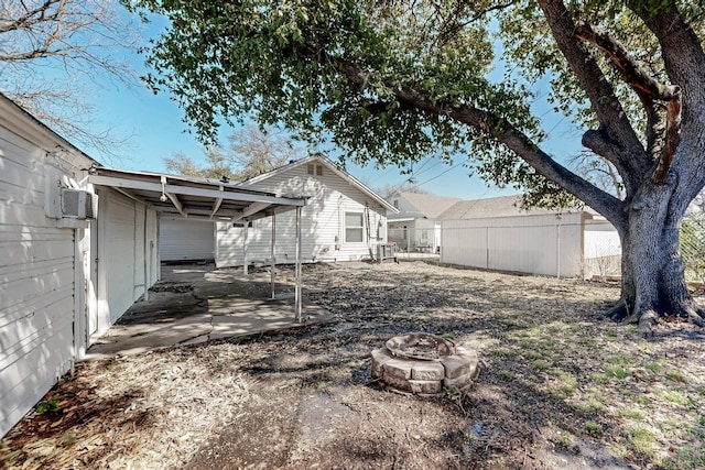 view of yard featuring a patio area, an outdoor fire pit, and fence