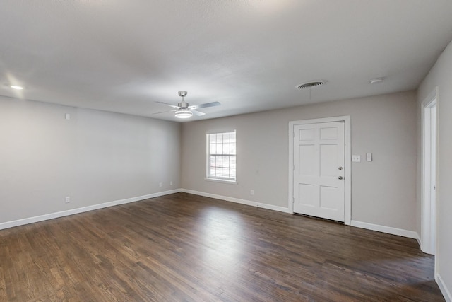 spare room with visible vents, dark wood finished floors, baseboards, and ceiling fan