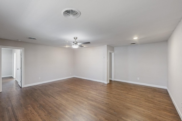 empty room featuring ceiling fan, dark wood-type flooring, visible vents, and baseboards