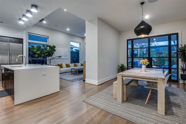 dining area featuring baseboards, visible vents, and light wood finished floors