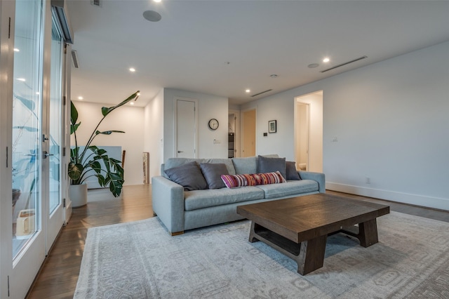 living room with wood finished floors, visible vents, and recessed lighting