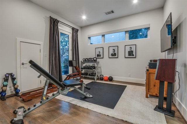 exercise room featuring baseboards, visible vents, wood finished floors, and recessed lighting