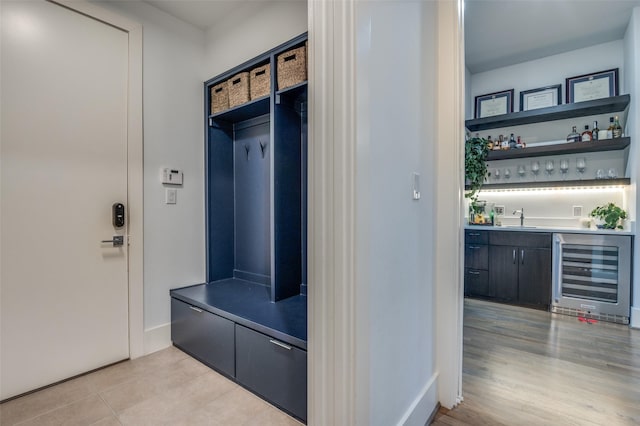 mudroom with beverage cooler, light tile patterned floors, indoor wet bar, and a sink