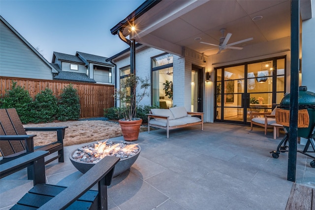 view of patio featuring a ceiling fan, fence, and a fire pit