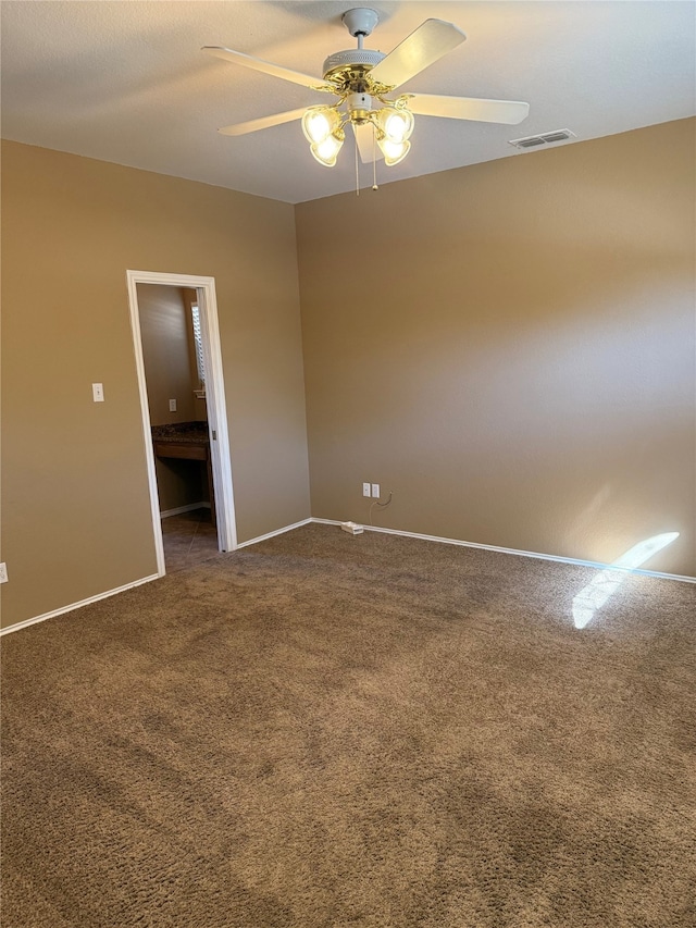 empty room with ceiling fan, baseboards, dark colored carpet, and visible vents