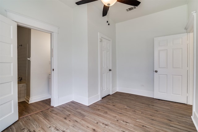 unfurnished bedroom with ceiling fan, wood finished floors, visible vents, and baseboards