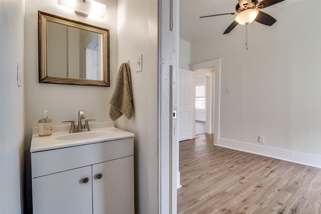 bathroom featuring a ceiling fan, vanity, baseboards, and wood finished floors