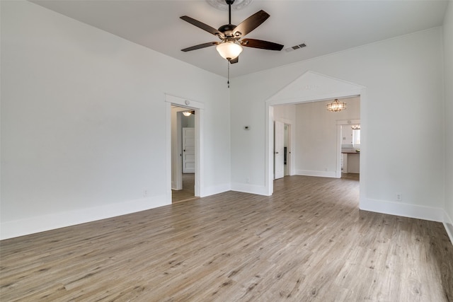 unfurnished room featuring baseboards, visible vents, wood finished floors, and ceiling fan with notable chandelier