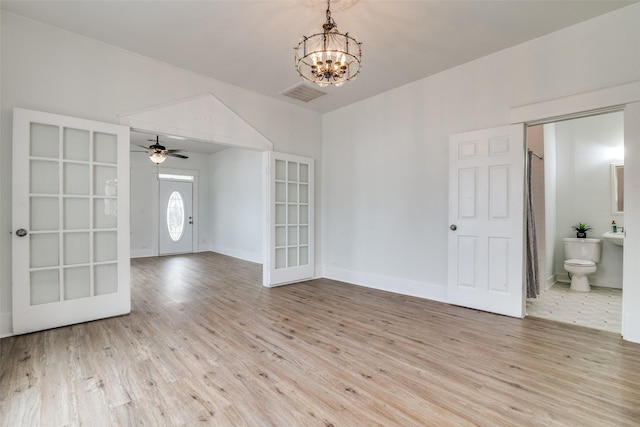 unfurnished room featuring light wood-style floors, baseboards, visible vents, and a chandelier