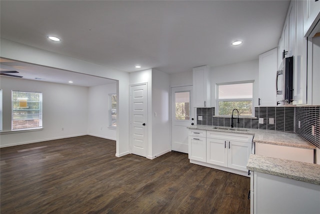 1422 W Austin St, Paris, TX 75460 - kitchen featuring decorative backsplash, dark wood-style floors, light stone countertops, white cabinetry, and a sink