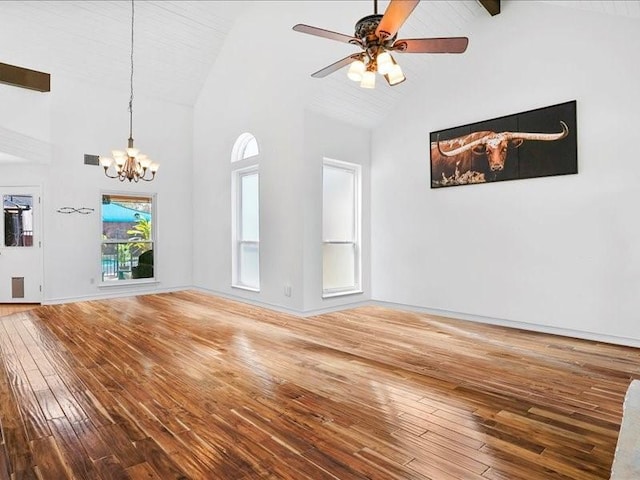 unfurnished living room with visible vents, hardwood / wood-style floors, high vaulted ceiling, baseboards, and ceiling fan with notable chandelier