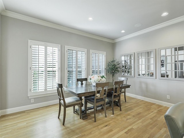 dining space with ornamental molding, light wood finished floors, and baseboards