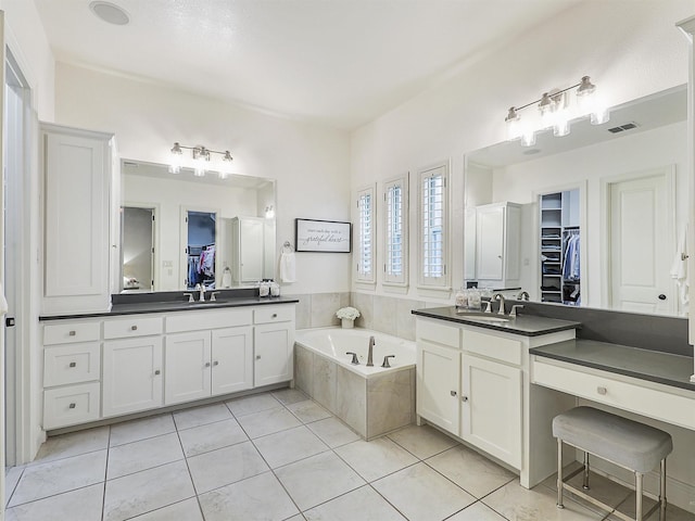 full bathroom with visible vents, a sink, a bath, and tile patterned floors