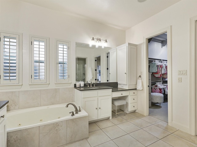 full bathroom featuring a tub with jets, tile patterned flooring, a spacious closet, vanity, and a walk in shower