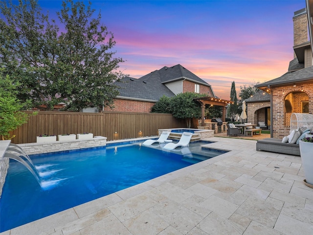 view of pool featuring a pool with connected hot tub, a patio area, a fenced backyard, and an outdoor living space with a fireplace