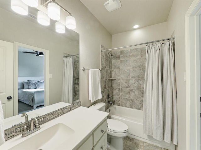 bathroom featuring toilet, shower / bath combo with shower curtain, and vanity