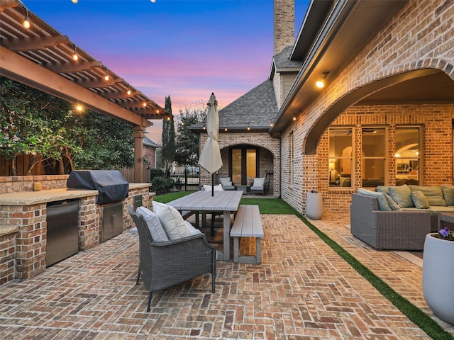 patio terrace at dusk with an outdoor hangout area, outdoor dining space, area for grilling, and a pergola