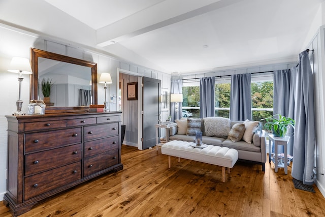 sitting room with wood-type flooring and lofted ceiling with beams