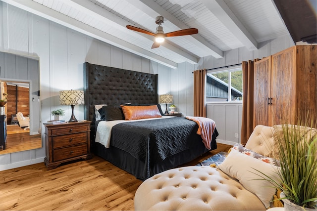 bedroom featuring ceiling fan, light wood finished floors, and beamed ceiling