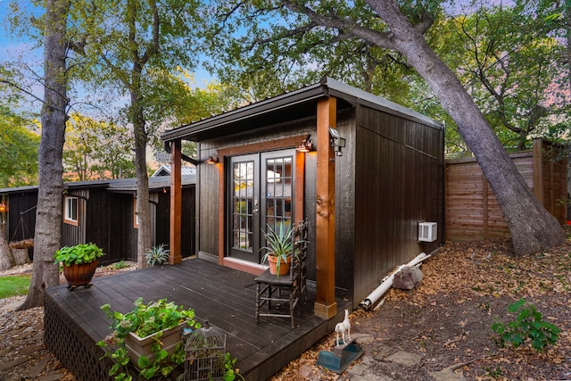 view of outbuilding with french doors and fence