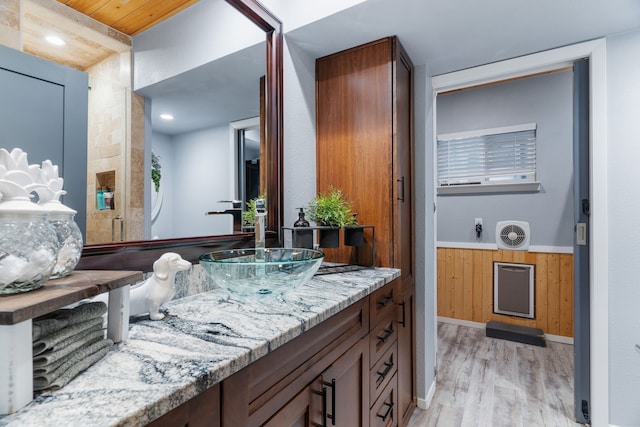 bathroom featuring a wainscoted wall, wood walls, wood finished floors, and vanity