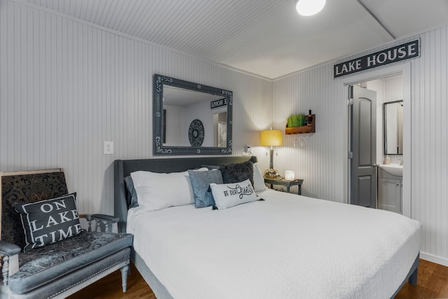 bedroom featuring dark wood-style flooring and ensuite bathroom