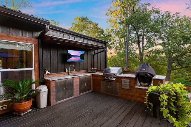 deck with exterior kitchen, a grill, and a sink