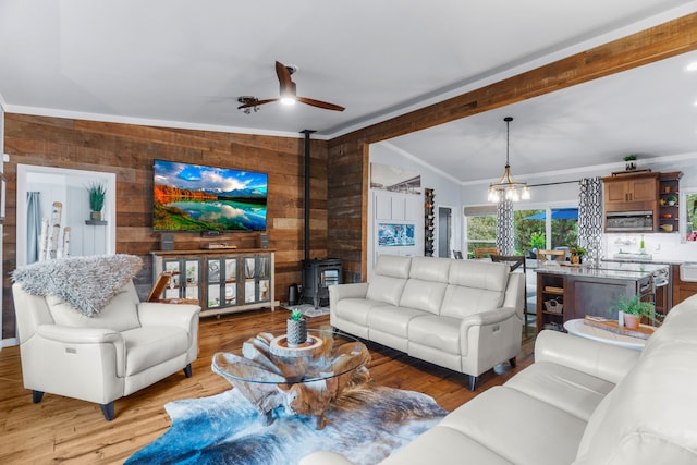 living room featuring vaulted ceiling with beams, wood finished floors, a wood stove, and wooden walls