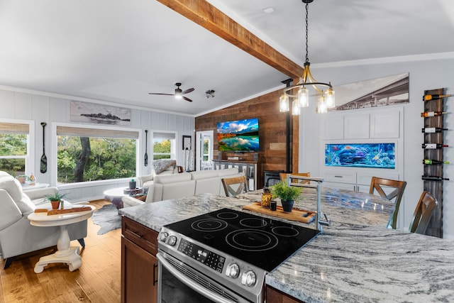 kitchen featuring open floor plan, vaulted ceiling with beams, light stone countertops, stainless steel electric range, and light wood-type flooring