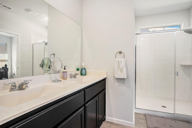 full bathroom with a stall shower, visible vents, a sink, and double vanity