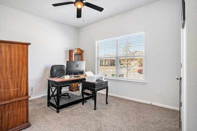 office area with carpet floors, a ceiling fan, and baseboards