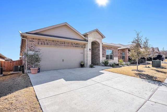 ranch-style home with a garage, stone siding, brick siding, and driveway