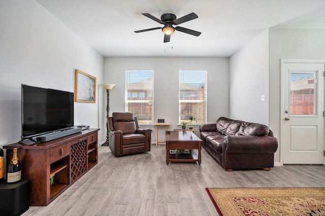 living room with baseboards, a ceiling fan, and wood finished floors