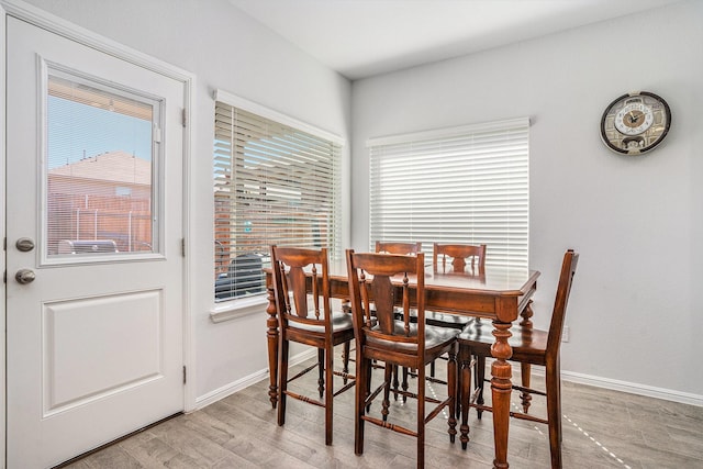 dining room featuring light wood-style flooring and baseboards