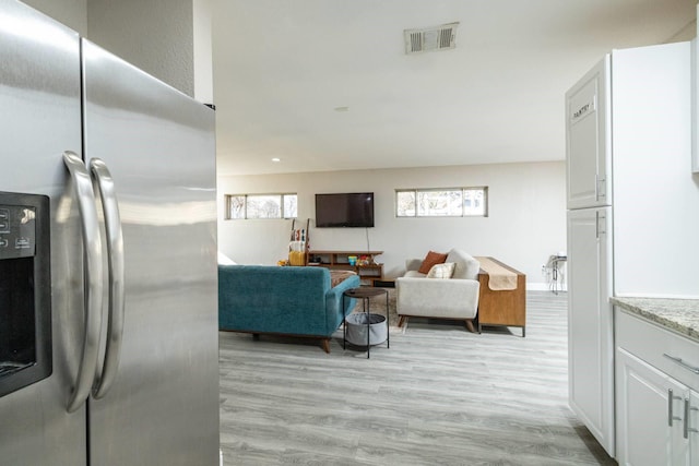 living room with visible vents and light wood-style floors