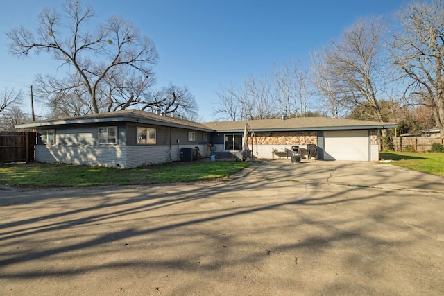 view of front of home featuring a garage, fence, driveway, and central air condition unit