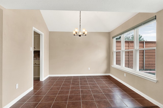 unfurnished room featuring vaulted ceiling, dark tile patterned flooring, baseboards, and a notable chandelier