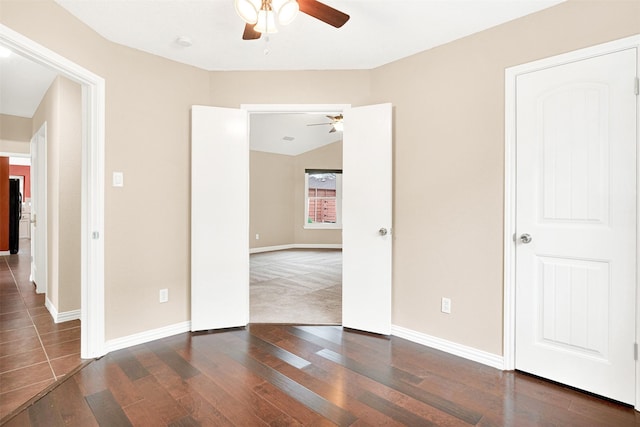 interior space with wood finished floors, a ceiling fan, and baseboards