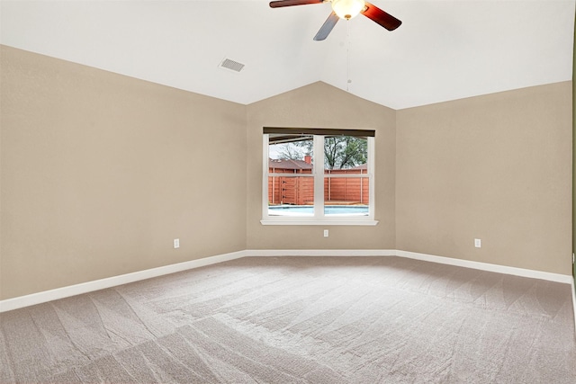 unfurnished room with lofted ceiling, carpet, visible vents, and baseboards