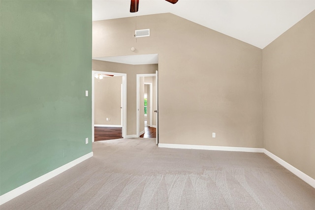 carpeted spare room with a ceiling fan, visible vents, high vaulted ceiling, and baseboards