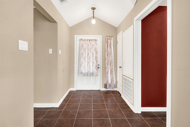 entryway featuring visible vents, baseboards, vaulted ceiling, and dark tile patterned flooring