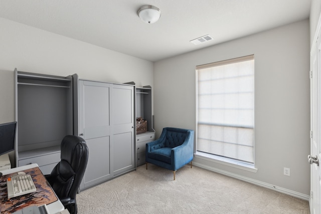 home office with baseboards, visible vents, and light colored carpet