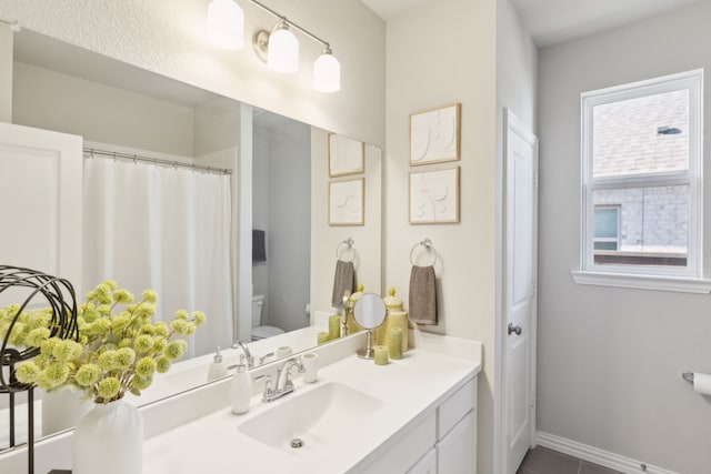 full bathroom with vanity, toilet, and baseboards