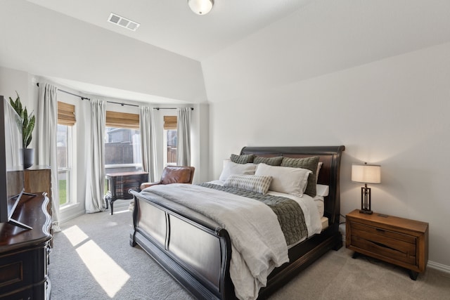 bedroom with light carpet, visible vents, and lofted ceiling