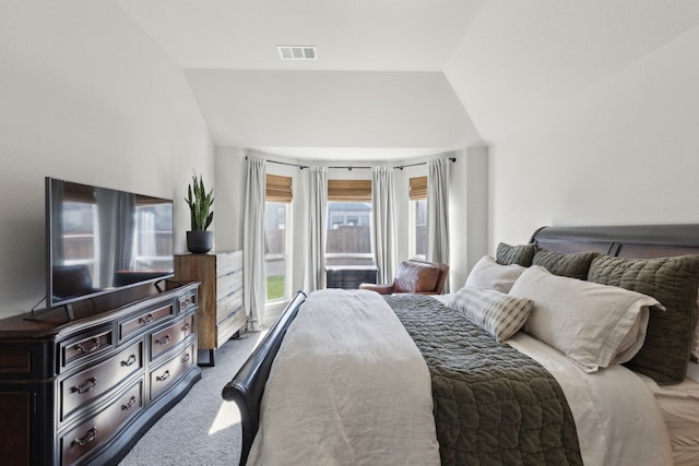 carpeted bedroom featuring visible vents and vaulted ceiling