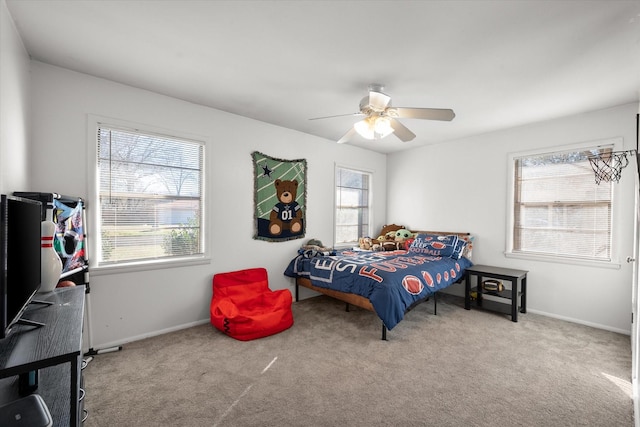 carpeted bedroom with ceiling fan and baseboards