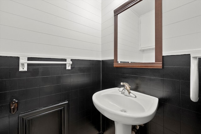 bathroom with tile walls and a sink