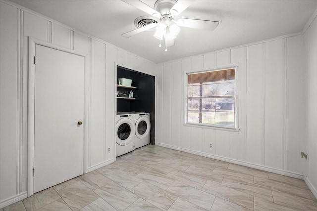 clothes washing area featuring ceiling fan, washer and clothes dryer, and a decorative wall