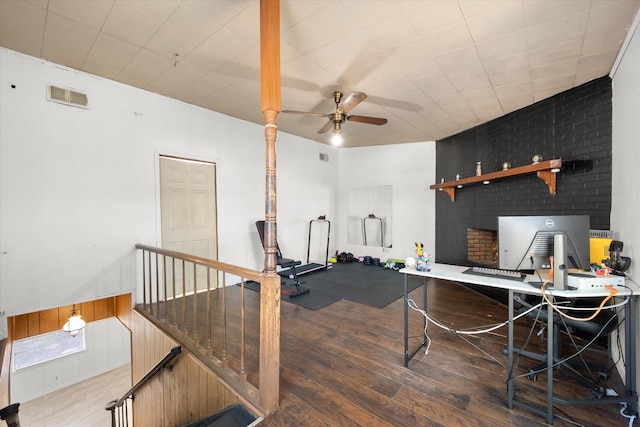 home office with a wainscoted wall, wood finished floors, visible vents, and a ceiling fan